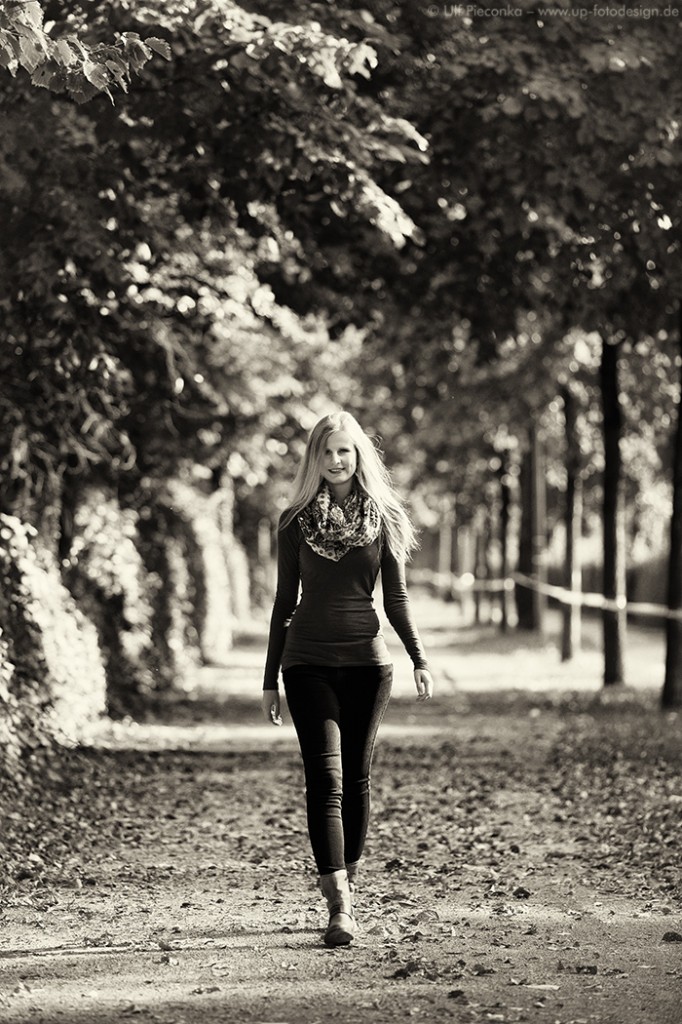 Model in Würzburg mit herbstlichem Licht und Laub von Bäumen - sw