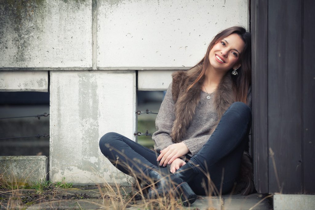 Model sitzend vor Mauer - Fotograf Würzburg